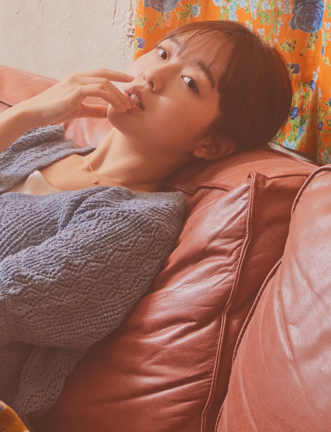 분홍색 소파에 누워있는 여성의 모습 :